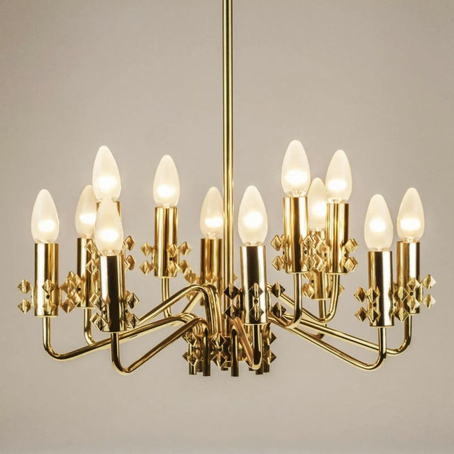 Original mid-century chandelier hanging light with 12 brass arms and beautiful decorative elements. Made in the 1960 in...