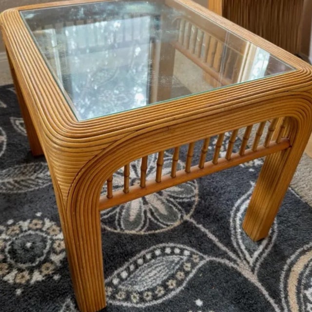 A beautifully crafted mid-century pencil reed rattan side table with its original glass top intact. The form is...