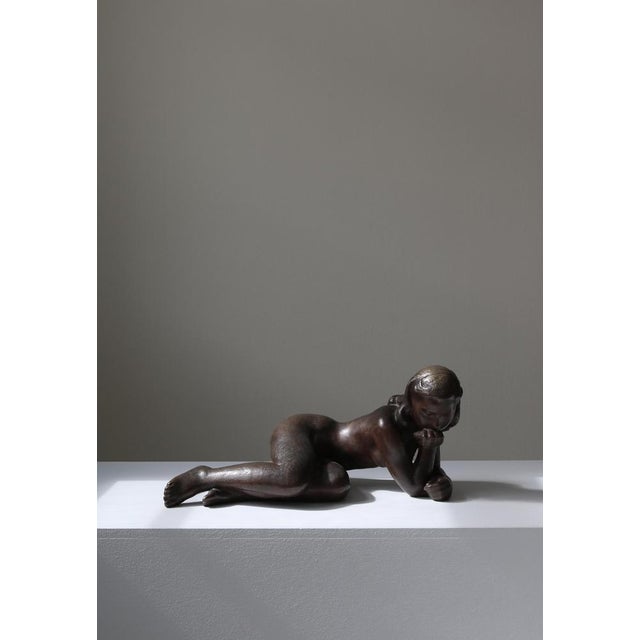 Large cast bronze sculpture by danish artist johannes hansen depicting a young girl lost in thoughts. The sculpture was...