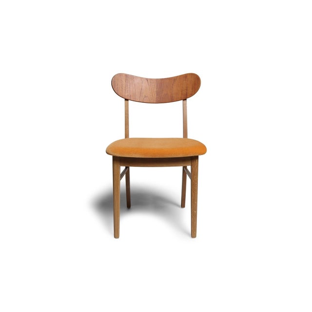 Set of eight mid-century Danish dining chairs handcrafted with solid oak frames, dramatic curved teak backrests. Newly...