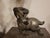 A striking solid metal ram sculpture featuring stylized curves, engraved detailing, and a bold, compact form. The raised...
