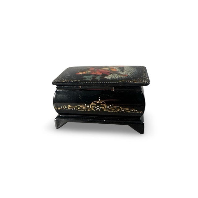 Small rectangular black lacquer box, made in Palekh, Russia. The artist is Moroz, and this is a folklore scene called...