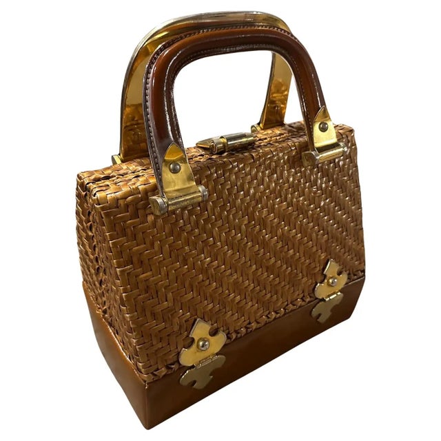 A Chic 1960s Italian Woven Wicker, Leather, and Brass Top Handle Bag by Rodo Embrace timeless summer style with this...