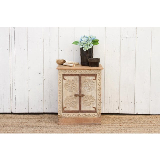 A rustic reclaimed teak nightstand cabinet, boasting a charming bleached finish. Crafted from an antique window door, this...