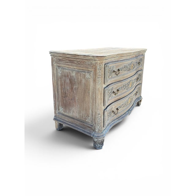 An exquisite late 18th to early 19th century French carved commode featuring three drawers, a later painted finish, and...