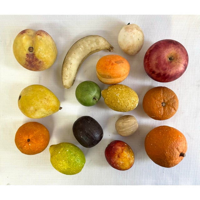 This set of carved stone fruit from Italy includes oranges, lemons, apples, a banana, nectarines, a walnut, a peach, and a...