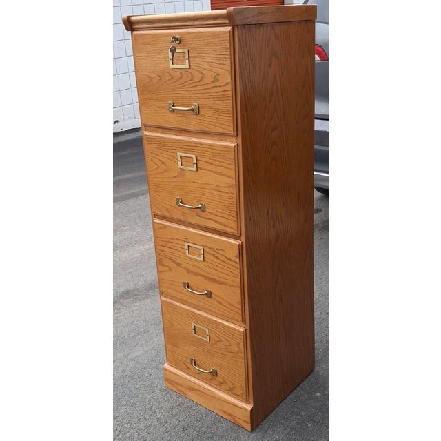 A Contemporary Oak Four-Drawer Filing Cabinet with locking top drawer. Measures 16" in width, 16.75" in depth and 51.75"...