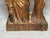 Hand-carved wooden religious figure accompanied by a decorative candle holder.