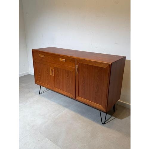 Mid-century modern sideboard produced by G-Plan , crafted in beautifully grained teak wood and elevated on black metal...