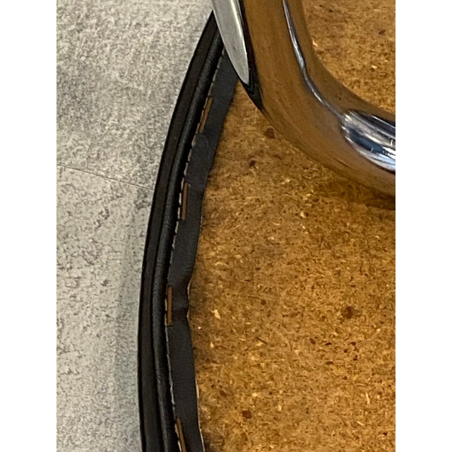 Round, chromed tubular steel legs; chrome in very good condition with some pitting. Wooden top covered in black vinyl with...