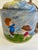 A charming vintage ceramic jug or decanter decorated with a hand-painted folk-art scene of children flying kites beside...