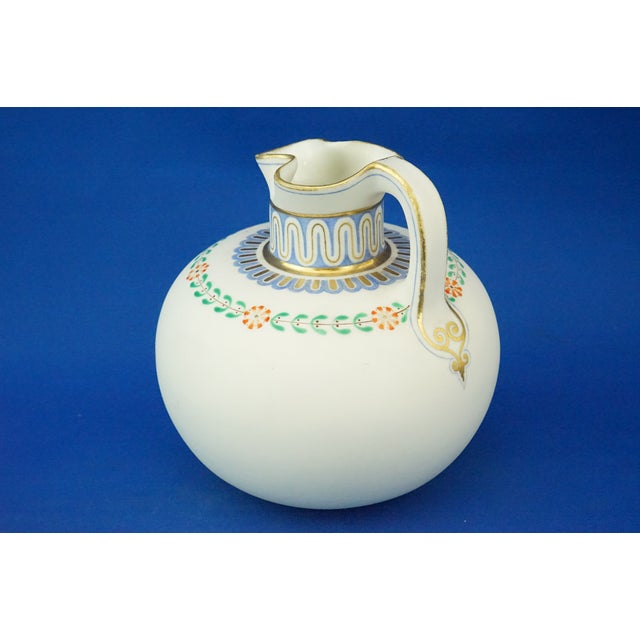 A beautiful Parian biscuit jug with a globular body, a cylindrical neck, and a trefoil mouth. Entirely hand-decorated with...