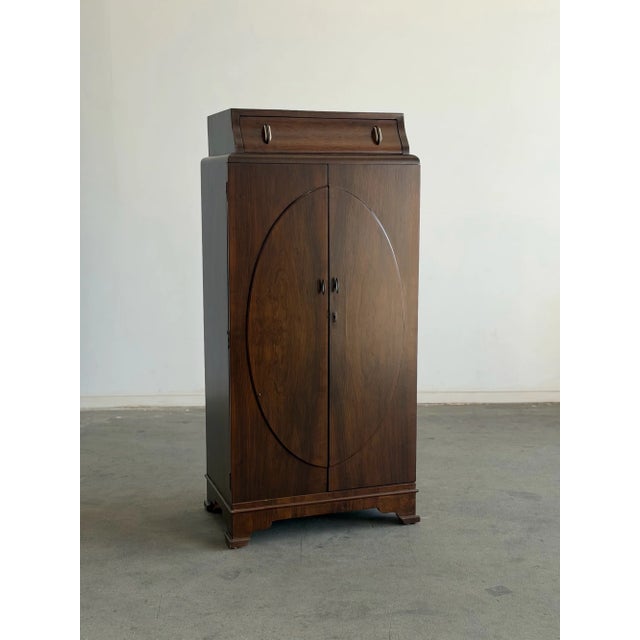 W28.5 D18 H60.5 Adjustable Shelf: Depth 16.25 Width 26.5 This restored art deco cabinet showcases a rich walnut veneer in...