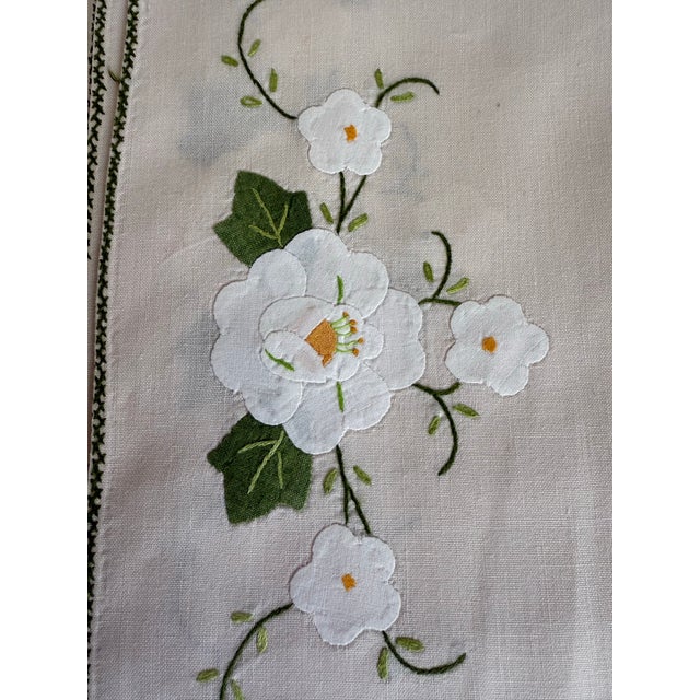 This charming set of eight vintage cotton placemats features delicate white floral appliqués and embroidery accented by...