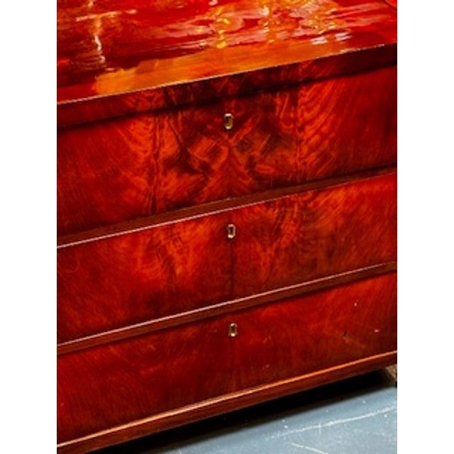 The 19th c. Biedermeier Flame Mahogany Chest is a stunning piece of antique furniture with a rich mahogany finish. This...