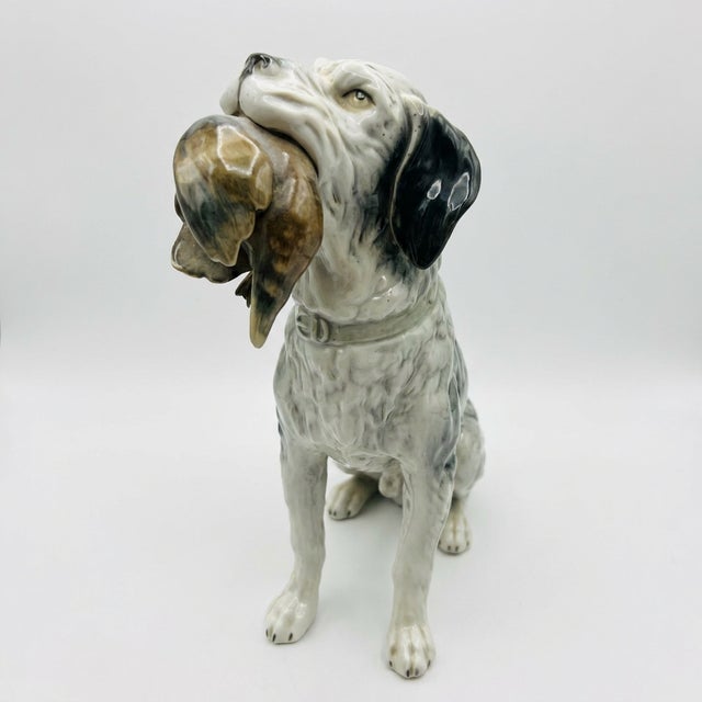 This rare handsome antique porcelain figure depicts a hunting dog, likely an English setter, captured mid hunt. Decorated...
