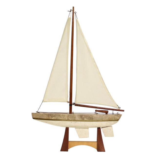 Vintage sailboat model with a tessellated stone clad hull and brass detail. Rests on a wood display stand. Material:...