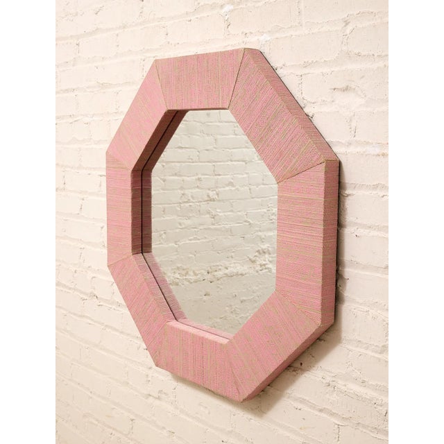 A wonderfully playful vintage wall mirror with a bold octagonal silhouette and an unexpected soft pink textile-wrapped...