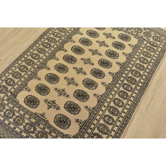 A tribal Bokhara rug hand-knotted with fine wool on a cotton foundation. This rug features rows of repeating medallions...