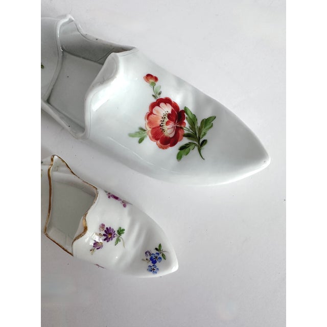 Two vintage Meissen decorative slippers with polychrome floral decoration on white porcelain. Two sizes, one 6.4”W x 2.3”D...