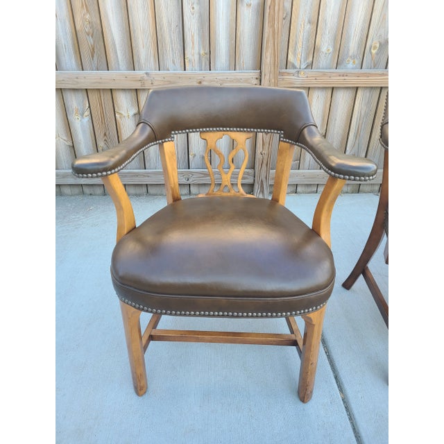 Four Chippendale inspired chairs. Dark brown leather, dark wood, and brass nailheads details. Well-made craftsmanship and...