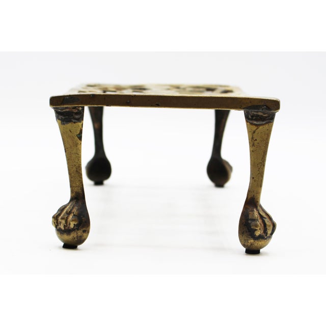 Late 18th century small brass footman trivet stand, English. Raised on turned, tapered legs with ball & claw feet. Cut &...