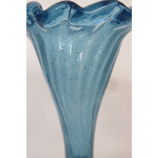 This brilliant aqua blue vase is made of handblown art glass. Presenting a stunning fluted ruffle trim at the top opening,...