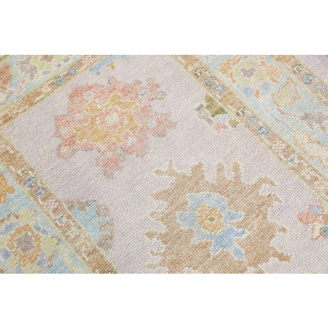 This modern Turkish Oushak rug is a stunning piece of art that has been handwoven using traditional techniques by skilled...