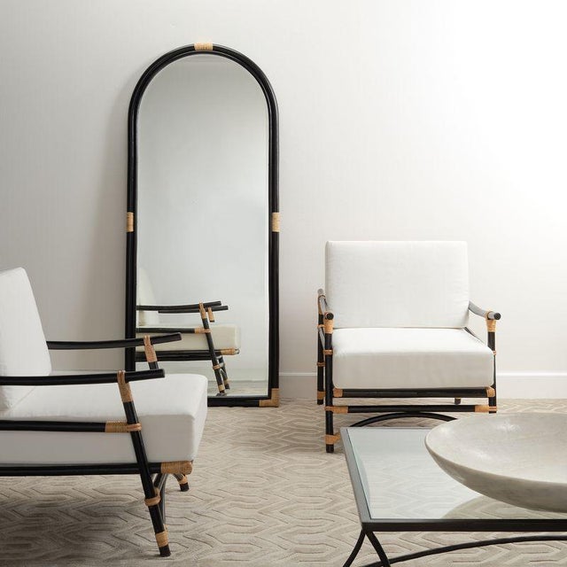 This gently arched, full length floor mirror’s rattan frame is subtly embellished with decorative notes in a contrasting...