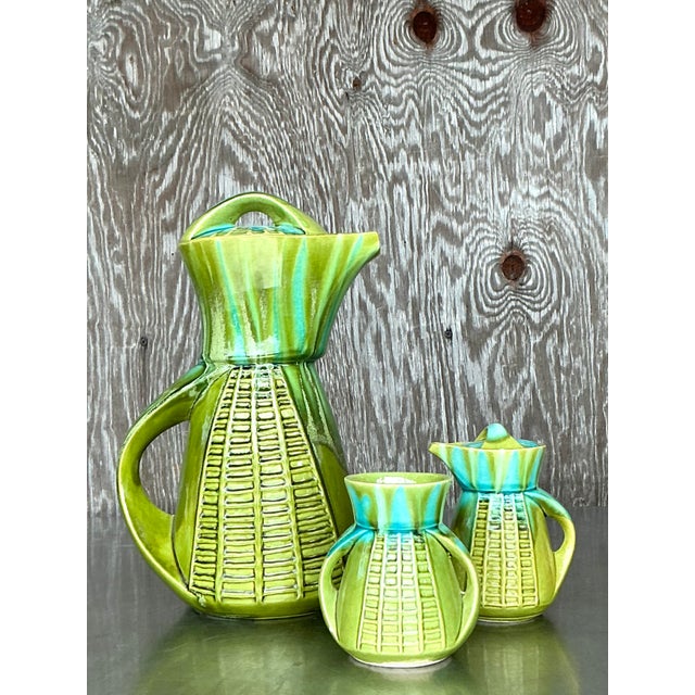 Infused with mid-century charm and California cool, this vintage glazed ceramic coffee service by Marcia of California is...