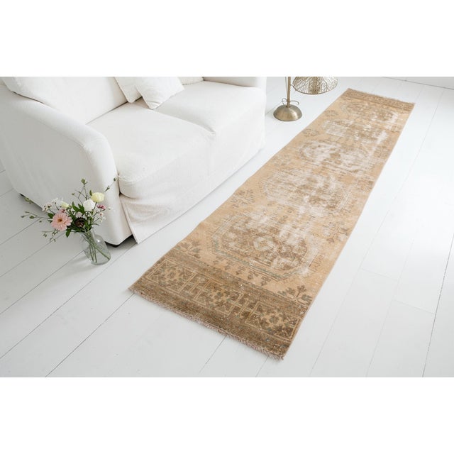 This is a vintage Turkish Oushak rug from the Mid 20th Century. The piece was hand-knotted.