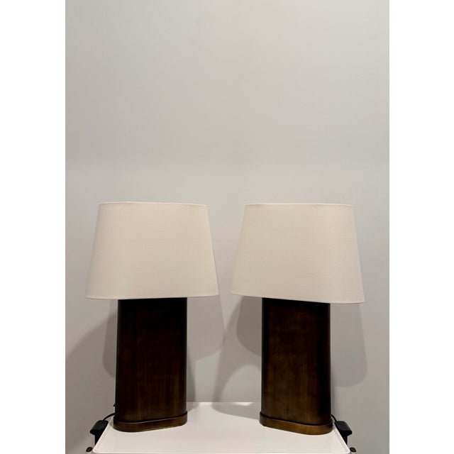 A handsome pair of Thomasville table lamps featuring sculptural bronze-finished column bases paired with clean off-white...