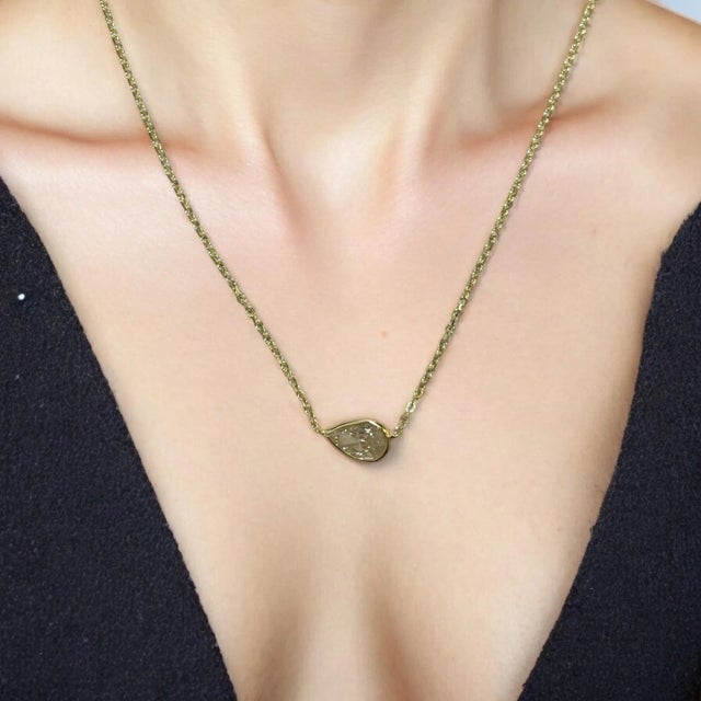 This majestic treasure features a stunning 1.03ct pear-cut natural diamond, securely bezel-set in radiant 14K yellow gold....