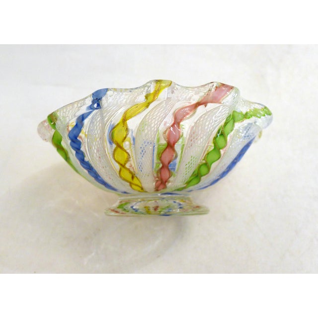 Tiny trinket dish from the 1960s. Round pedestal base, oval-shaped container with a wavy, corolla-shaped rim. Made...