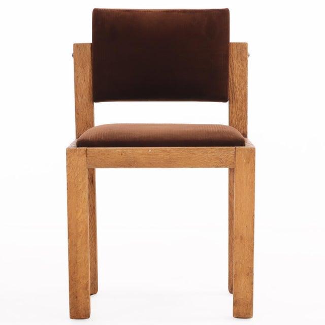 French Brutalist-style oak side chairs, circa 1960, featuring boldly constructed frames and fully tilting backs. The...