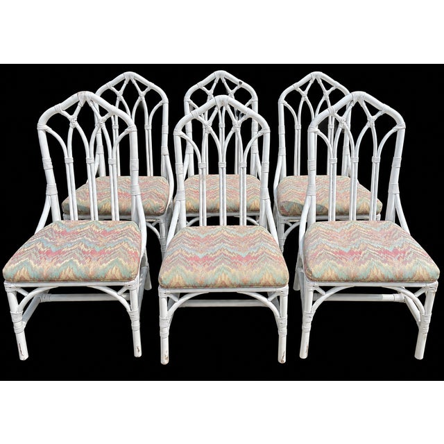 Offered is a set of six vintage Henry Link Cathedral rattan dining chairs. These iconic Hollywood Regency style pieces...