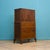 A 1930s Art Deco oak tallboy with a cupboard top section over three drawers, raised on carved shaped feet. The upper...