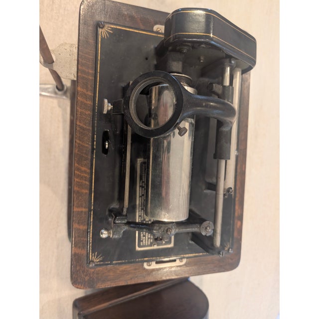 Antique Thomas Edison cylinder phonograph featuring a striking black flared horn and rich wood base. This early 20th-...