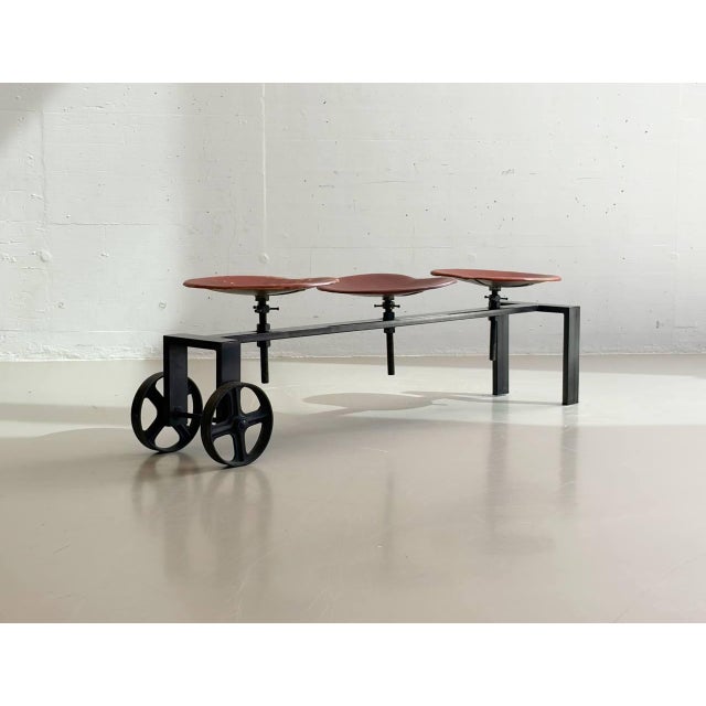 An exceptional industrial bench by kare design, featuring a striking combination of black lacquered steel, cast iron...