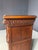 This ornate carved wooden cabinet features two paneled doors, two upper drawers, and an elaborately decorated facade. The...