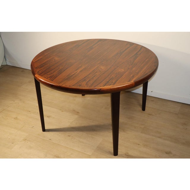 Elegant Scandinavian rosewood dining table by V.V. Møbler. Its gently curved top showcases the wood's beautiful, warm, and...