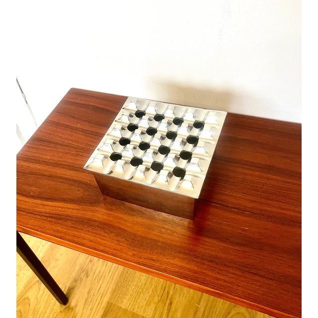 Vintage chrome-plated metal table ashtray with a bold geometric design, its textured construction lending it a truly...