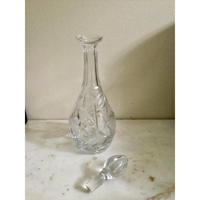 Elegant vintage cut crystal decanter featuring an exquisite leaf pattern, beautifully detailed with frosted crystal...