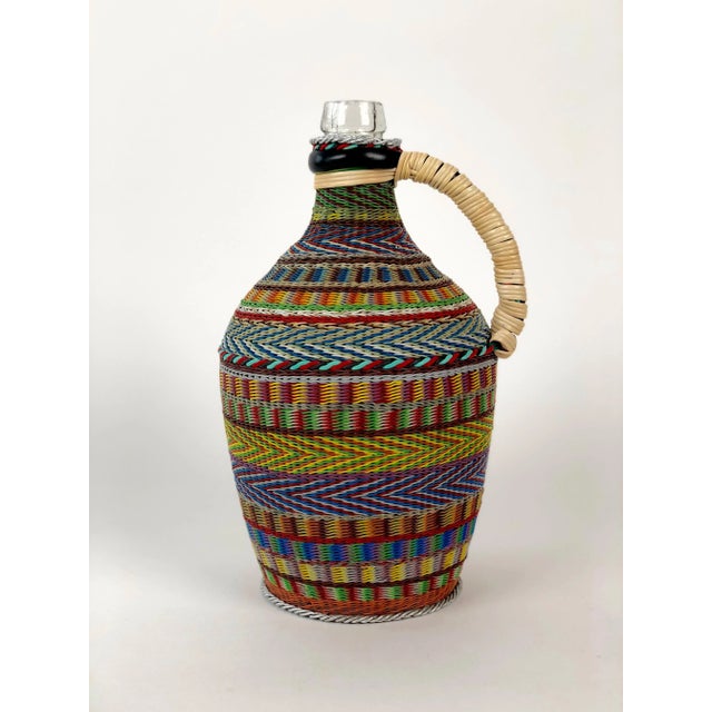 Vintage woven wire decorated wine bottle. The pattern and technique are based on traditional basket weaving. The results...