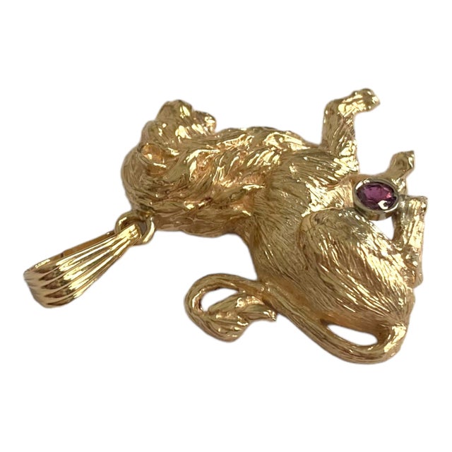 Crafted in 14K yellow gold, the pendant features a side image of a sitting lion accented with a bezel set garnet. Textured...
