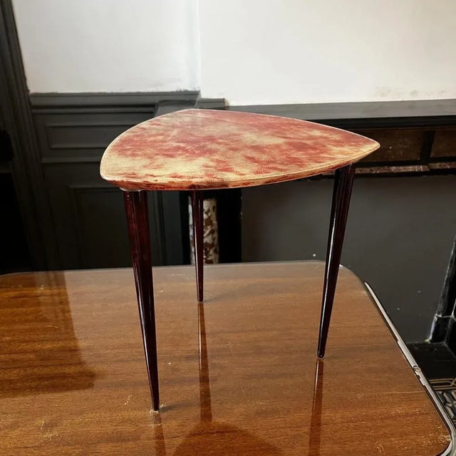 Elegant little tripod coffee or occasional table in red-tinted goatskin parchment and lacquer, created by the italian...