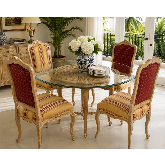 Elegant vintage dinette set featuring a sculptural French Provincial style base with a large round glass top and four...