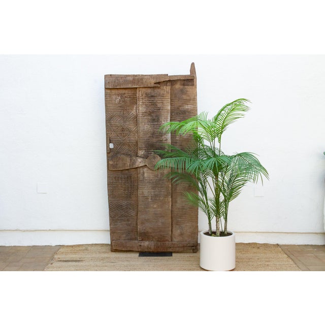 From the Awka region of northern Igbo territory in Nigeria, this monumental three-plank door represents a mgbo ezi, or...