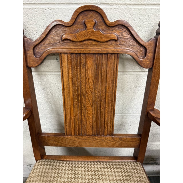 This is a beautiful set of six vintage Jacobean Revival or English Tudor style oak dining chairs, including one armchair...