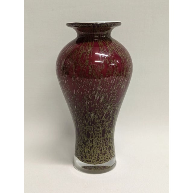 A striking tall oxblood red and gold art glass vase (10.5"). The heavyweight vase has a unique gold drizzle with a clear...